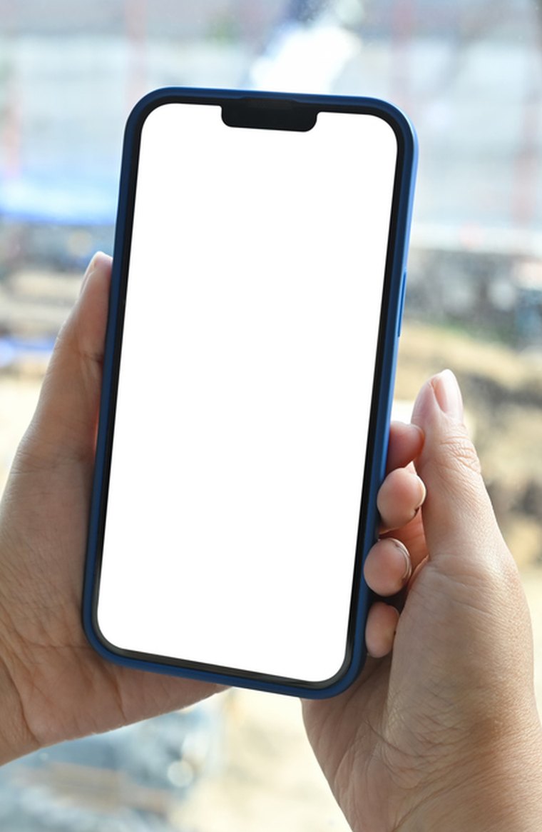 A jobsite foreman holding a phone showing a text message that the mixer is en route with its ETA